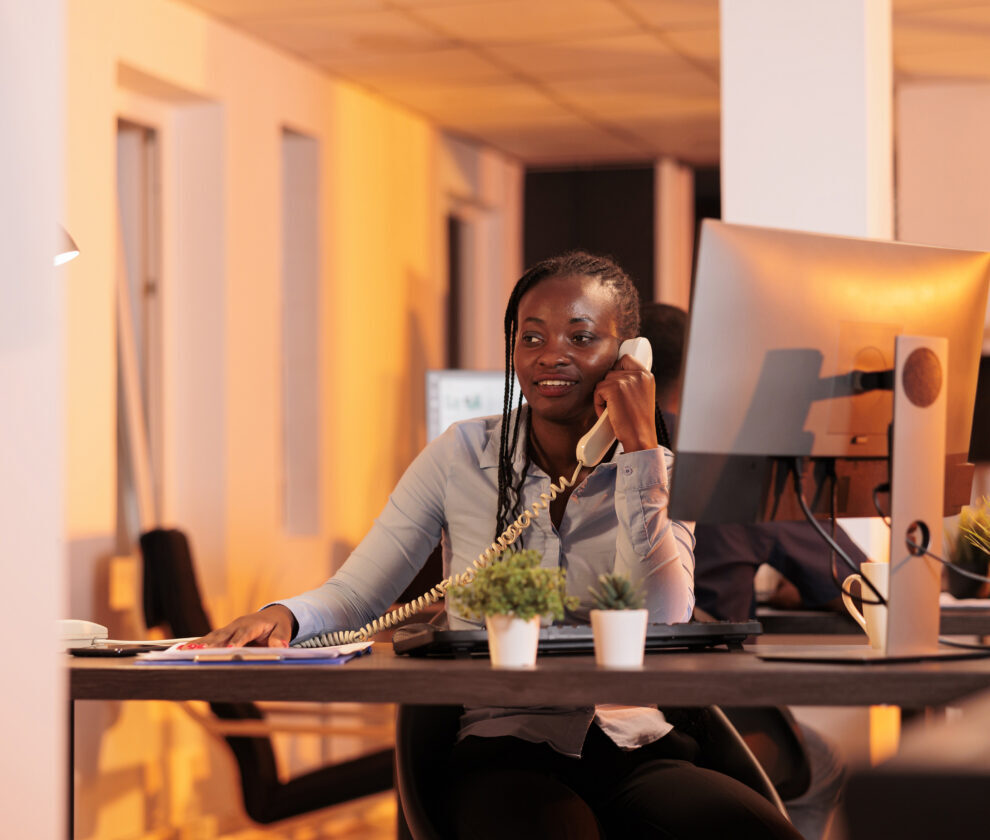 Office secretary answering landline phone call to talk about business research