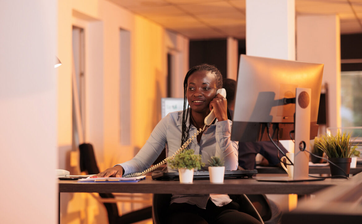 Office secretary answering landline phone call to talk about business research