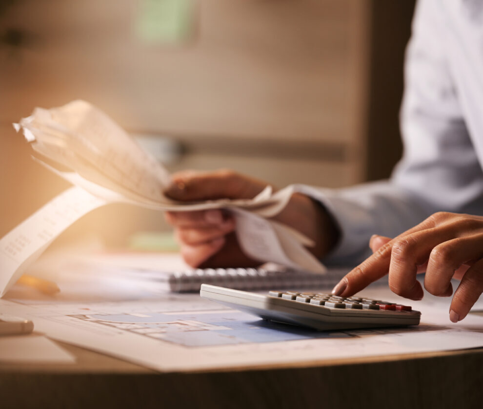 Close-up of business accountant using calculator while working i