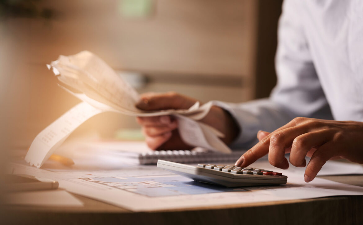 Close-up of business accountant using calculator while working i